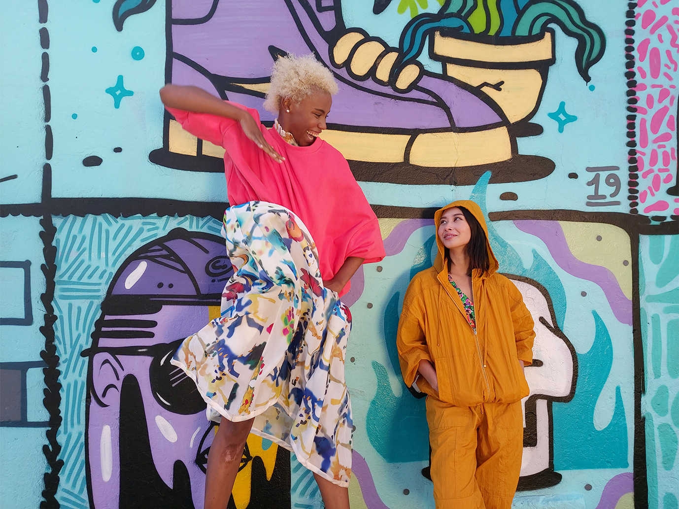 Photo capturÃ©e par l'objectif grand angle du Galaxy A80 composÃ© de deux femmes, l'une haute et l'autre courte, devant un mur de graffitis.